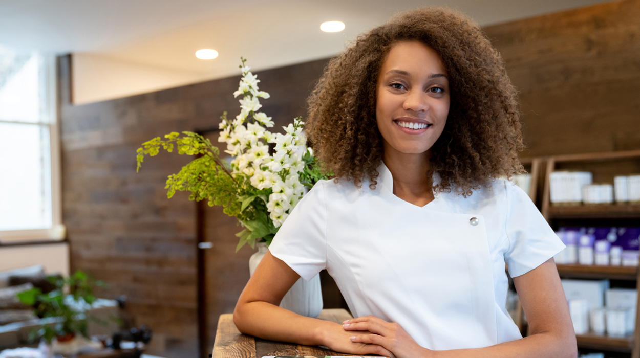 Aesthetician in medical spa lobby waiting to greet client with a smile