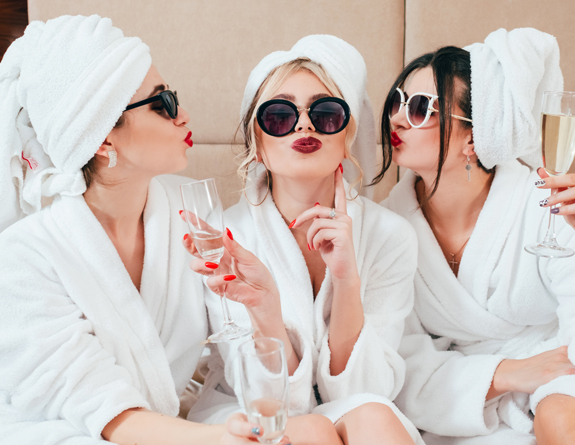 Medical spa employees celebrating in a medical spa with robes and champagne.