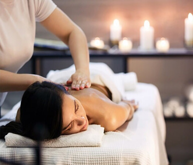 A person getting a massage in a candle lit room