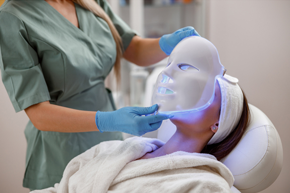 Physican applying LED Light Therapy Mask to clients face at a Medical Spa Practice