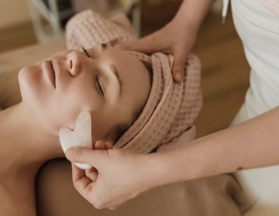 Client getting Gua Sha facial to help seasonal allergies