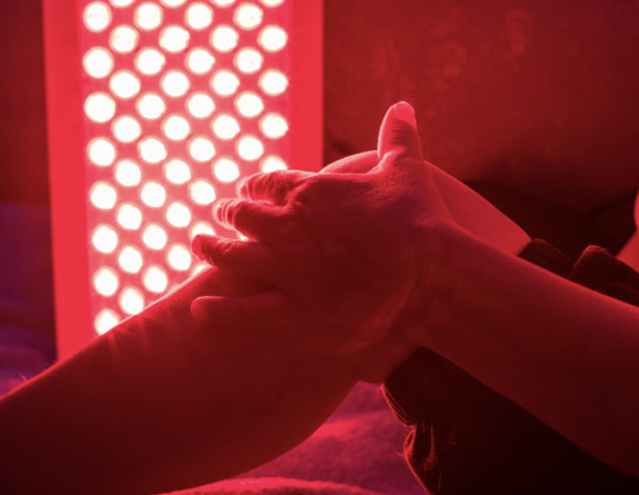 Client receives pain management red light therapy, and their progress is tracked through the best medical spa software.