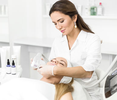 Medical Spa Practitioner with client in chair performing a medical spa treatment on her face