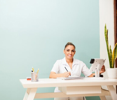 Med Spa Receptionist at desk using tablet