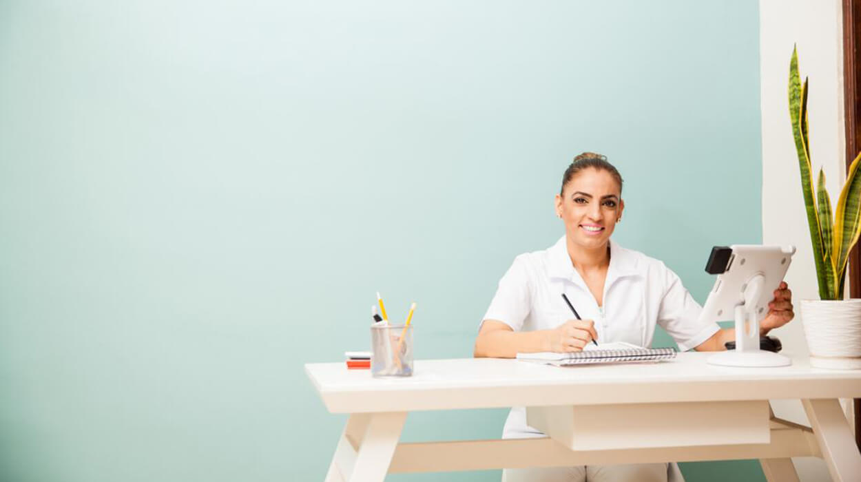 Med Spa Receptionist at desk using tablet