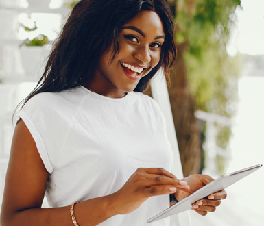 Aesthetician smiling and using spa software for small business on a tablet.